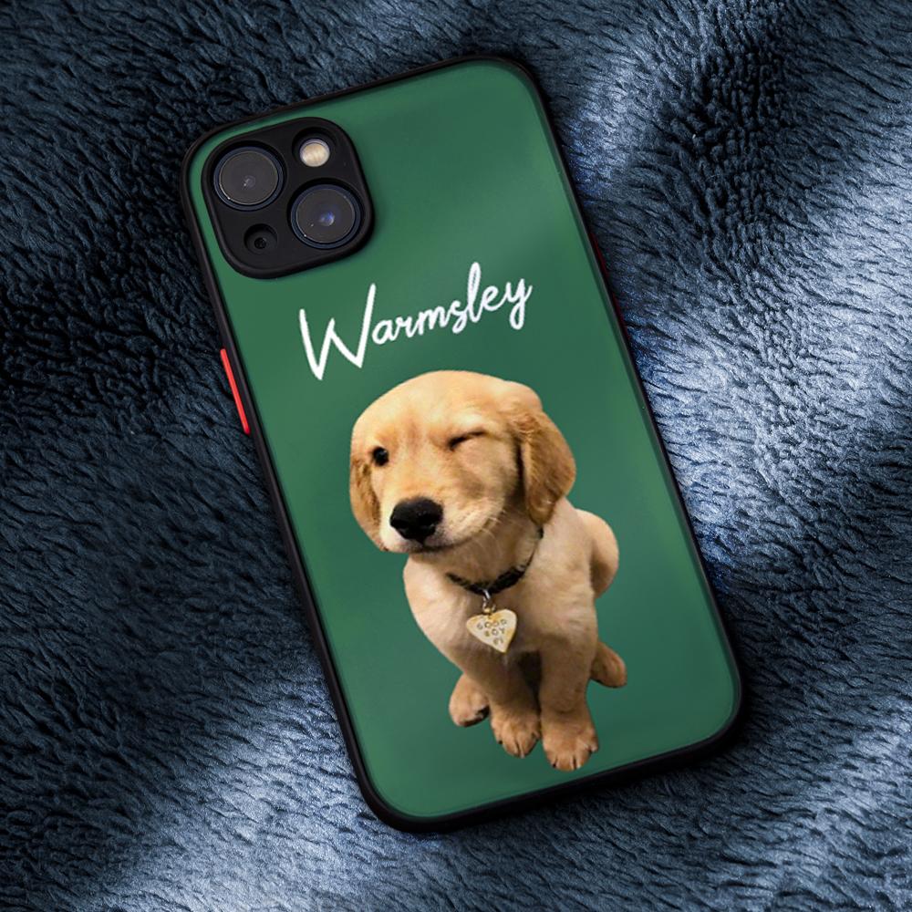 A green custom pet photo iPhone case lying on a soft blanket, showing the raised camera bumper edge