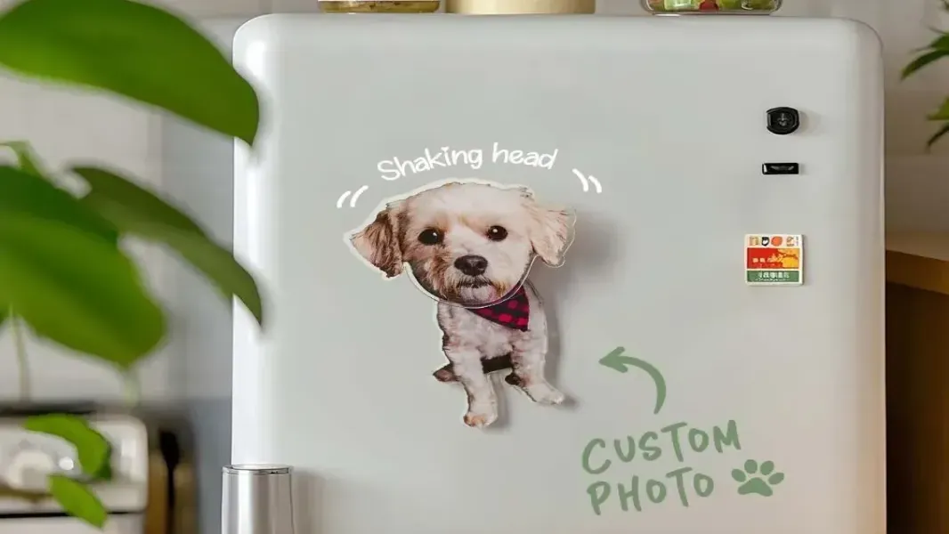 Personalized pet portrait fridge magnet displayed on a white refrigerator surrounded by postcards and a grocery list note