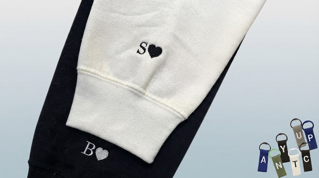 Close-up of embroidered heart and initial on the sleeve of a matching couple hoodie