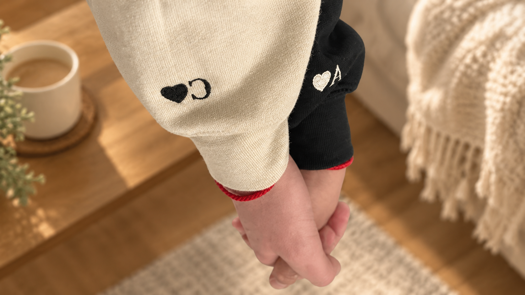 Close-up of a small heart and initial embroidered on a hoodie sleeve for personalized hoodies for couples