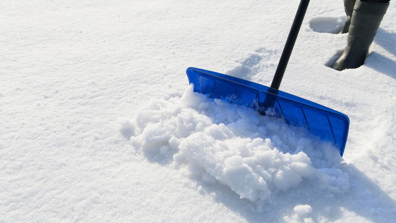 clearing driveway snow with a shovel