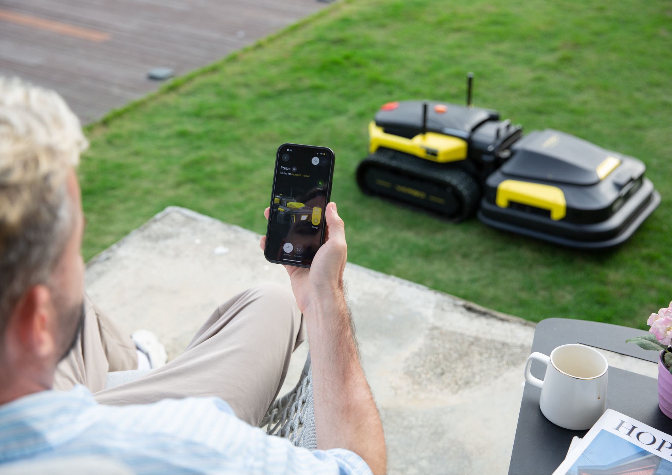 Dad relaxing and using yarbo's robot lawn mower 
