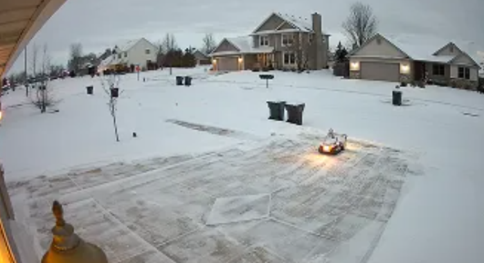 electric snow blower clearing a driveway