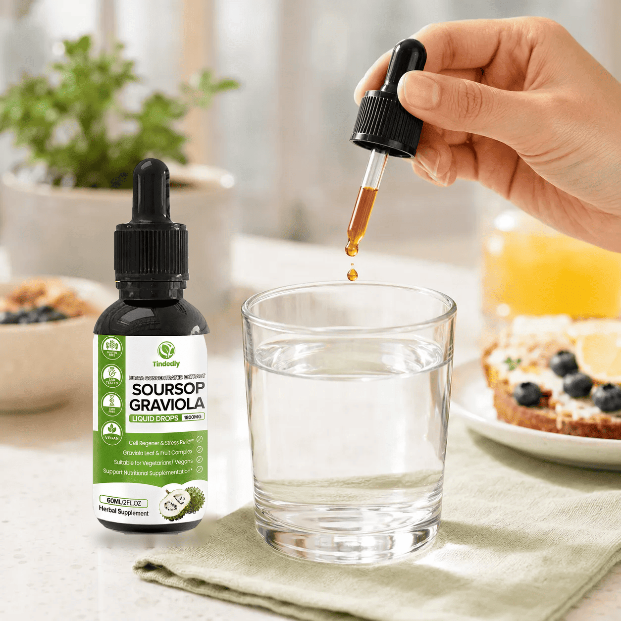 Tindedly Organic Soursop Extract dropper adding liquid to a glass of water