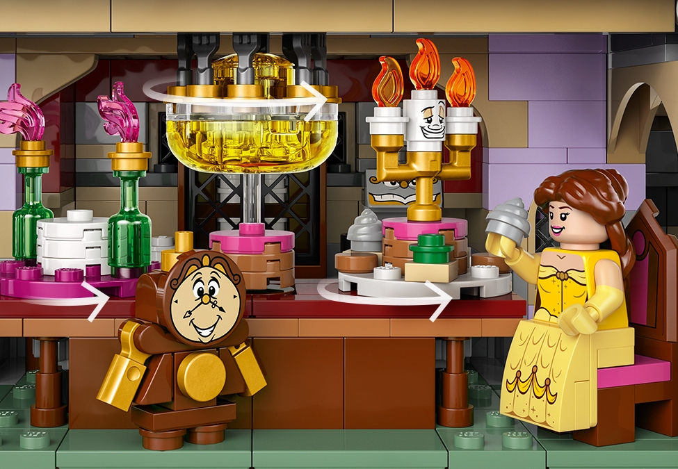 Belle sitting at the dining room table with the spinning platter along with Cogsworth and Lumière.
