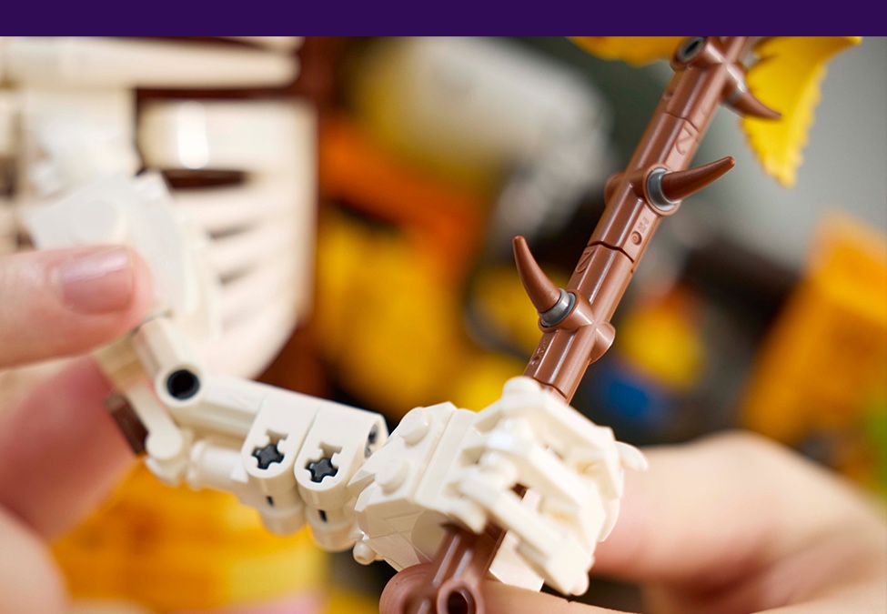 Hands building the LEGO Fortnite Peely Bone figure