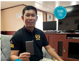 Seafarer customer holding a portable WiFi device aboard a vessel, in a photo supplied by NomadsFi.