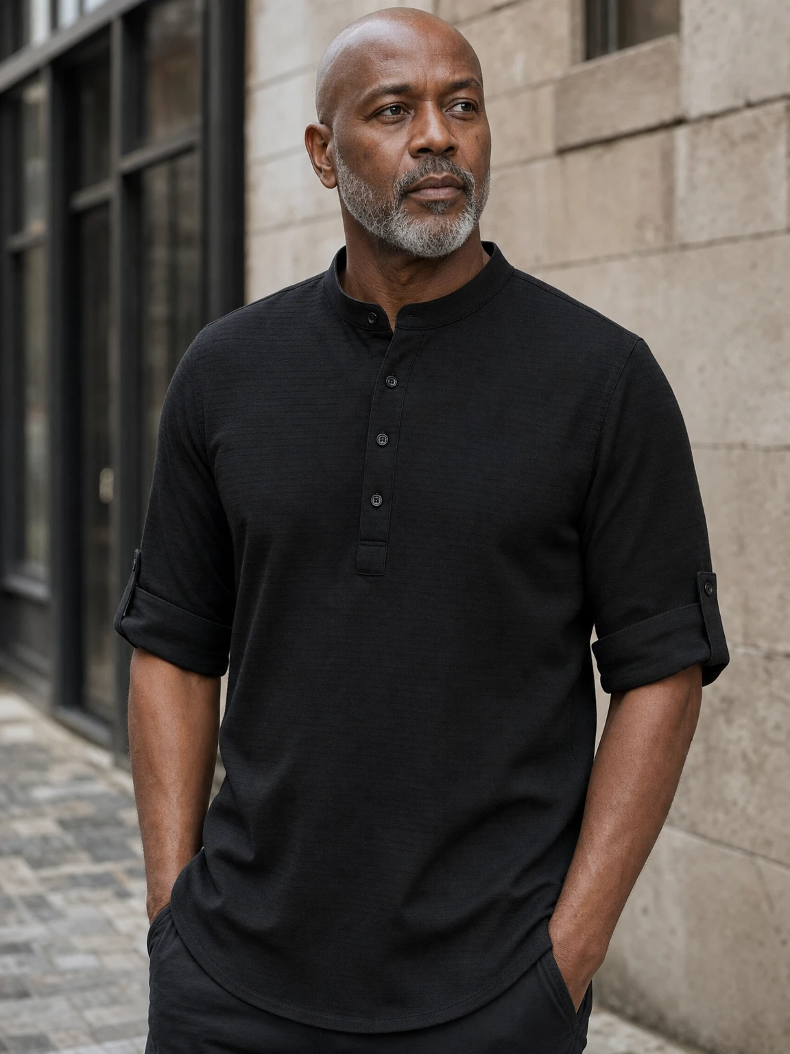 Mature Black American male model wearing the black Porto Henley on a city street