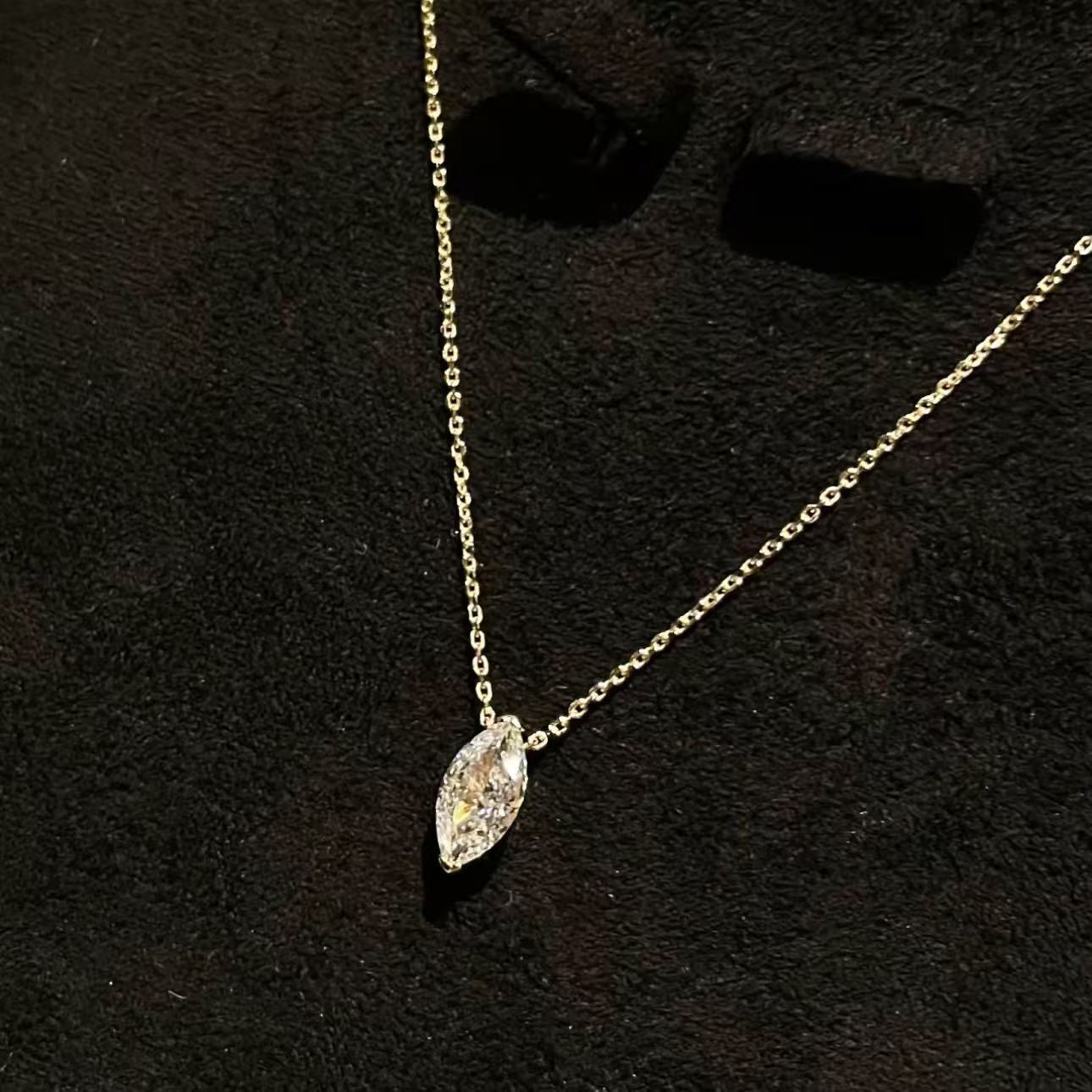 Brilliant marquise cut simulated diamond pendant on a delicate platinum chain against black background