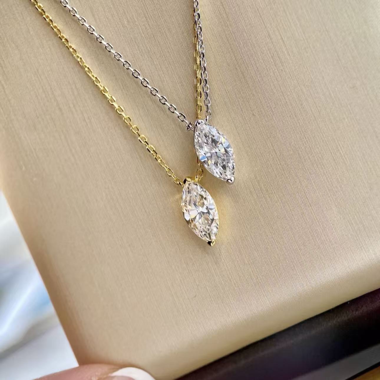18k gold and platinum plated silver marquise cut necklaces side by side