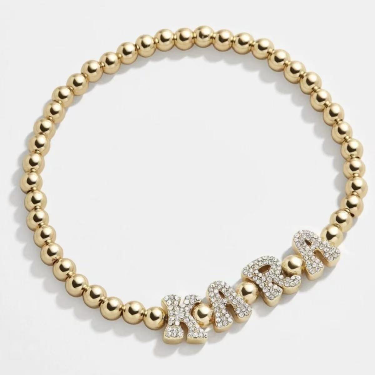 18k gold plated beaded stretch bracelet featuring custom pave cubic zirconia letters spelling KARA