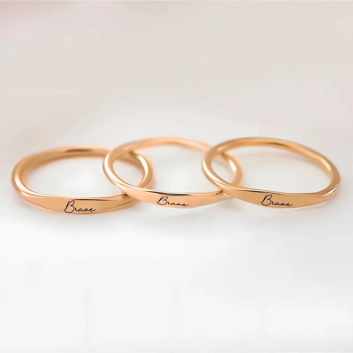 Inspiration at Your Fingertips - Rose Gold 'Brave' Rings, a Daily Reminder of Courage. #RoseGoldRings #EmpoweringJewelry #BraveRings