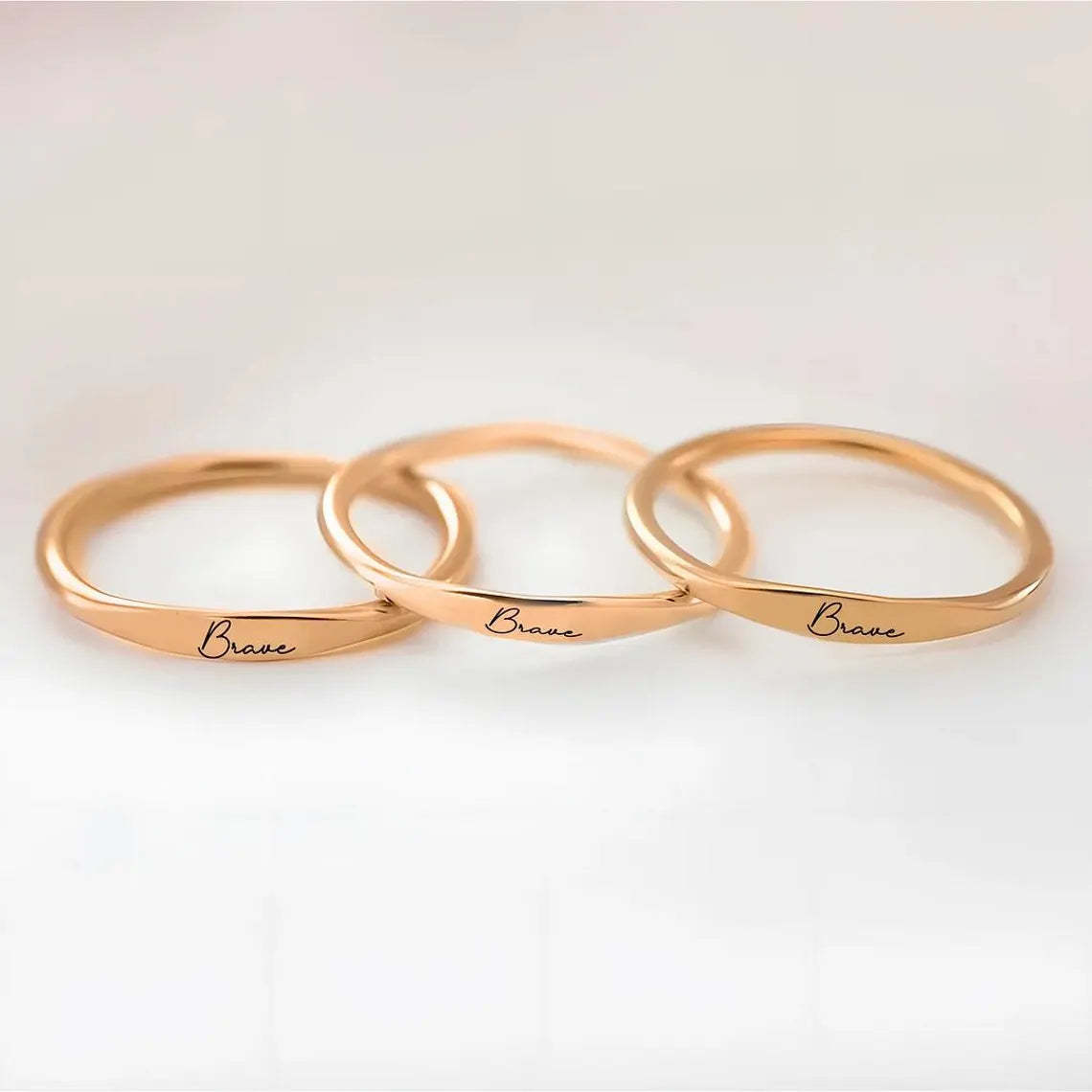 Inspiration at Your Fingertips - Rose Gold 'Brave' Rings, a Daily Reminder of Courage. #RoseGoldRings #EmpoweringJewelry #BraveRings