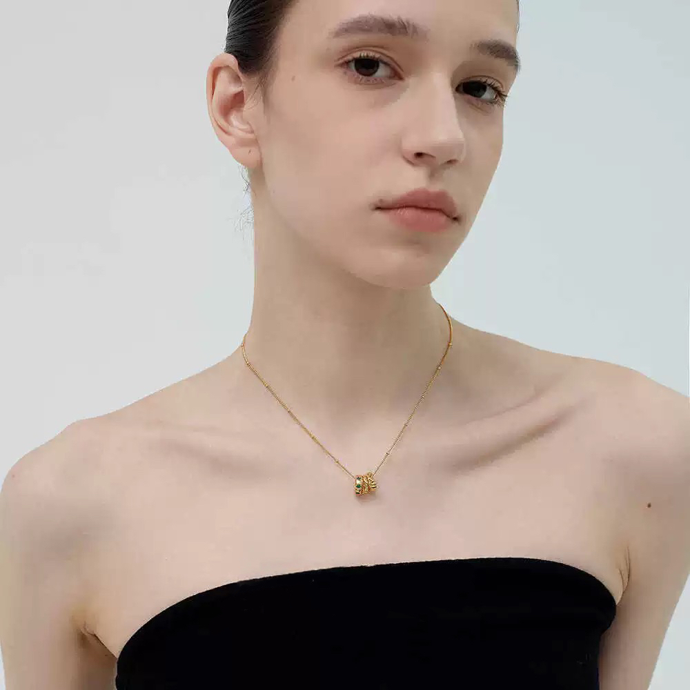 Gold-tone necklace with three emerald gemstones