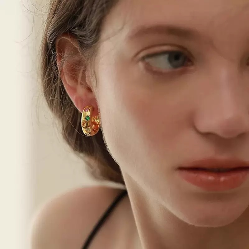 Gold and silver hoop earrings with colorful gemstones