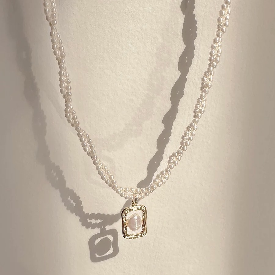 Gold-tone necklace with pearl and square pendant