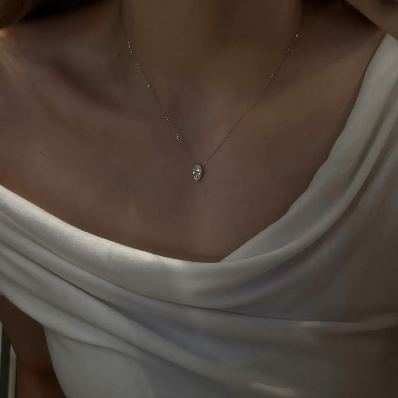 Model wearing an elegant platinum plated marquise cut diamond pendant necklace