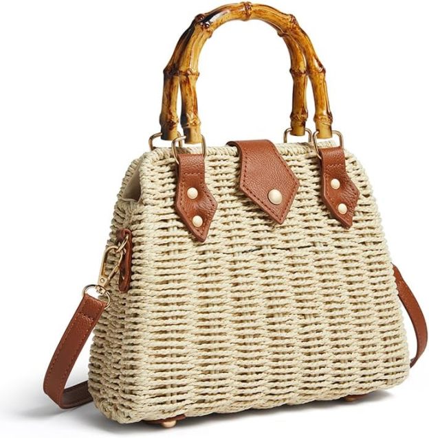 Natural woven straw handbag featuring a bamboo handle, brown leather trim, and a detachable crossbody strap, displayed against a neutral background.

