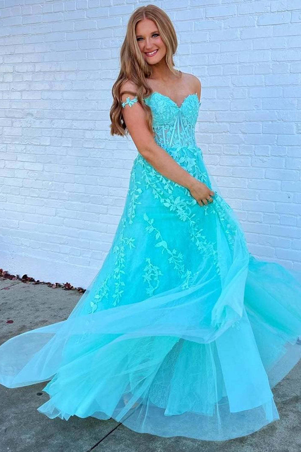 Prom dress in navy featuring off-the-shoulder design and appliques