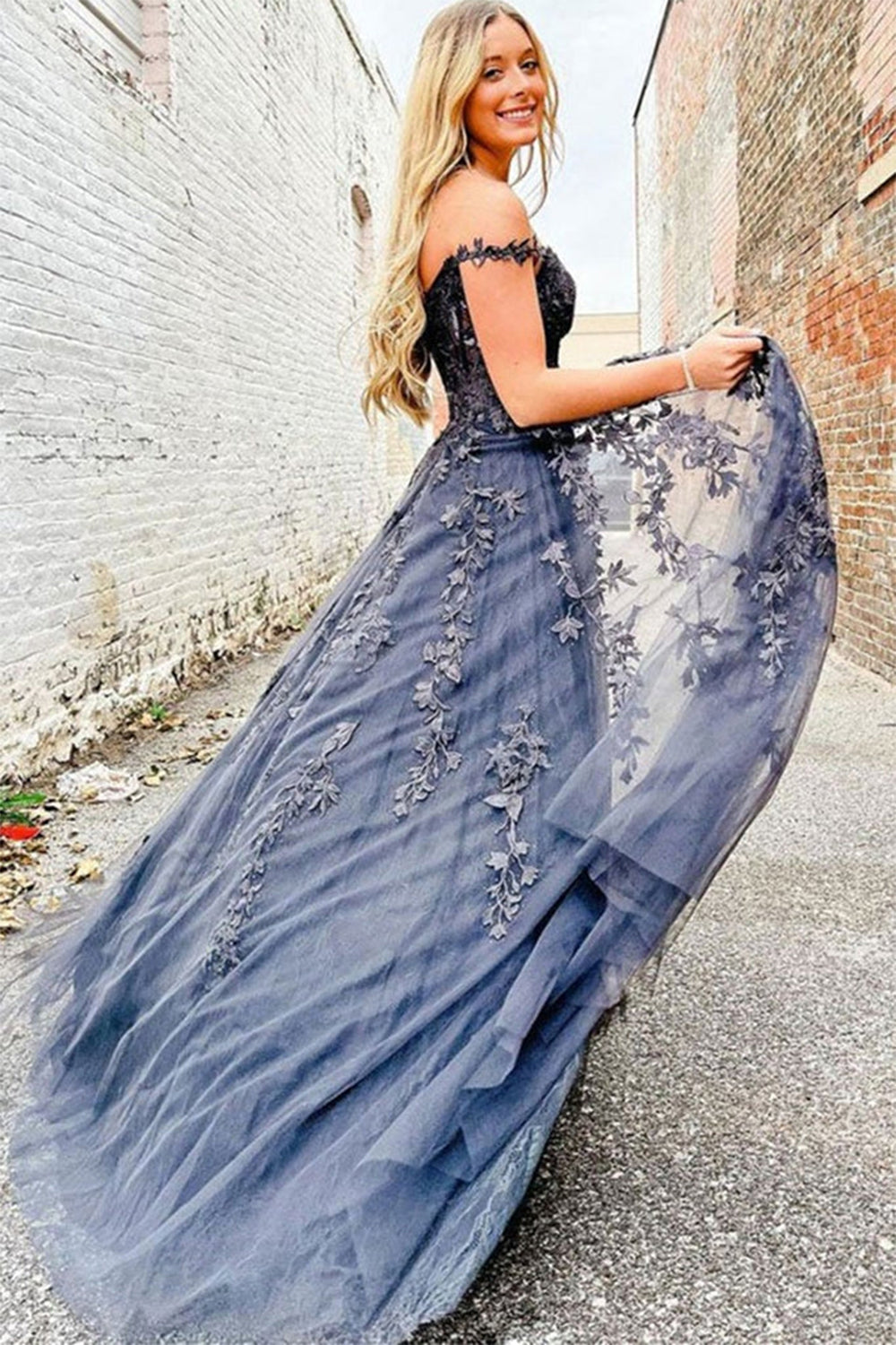 Prom dress in navy featuring off-the-shoulder design and appliques