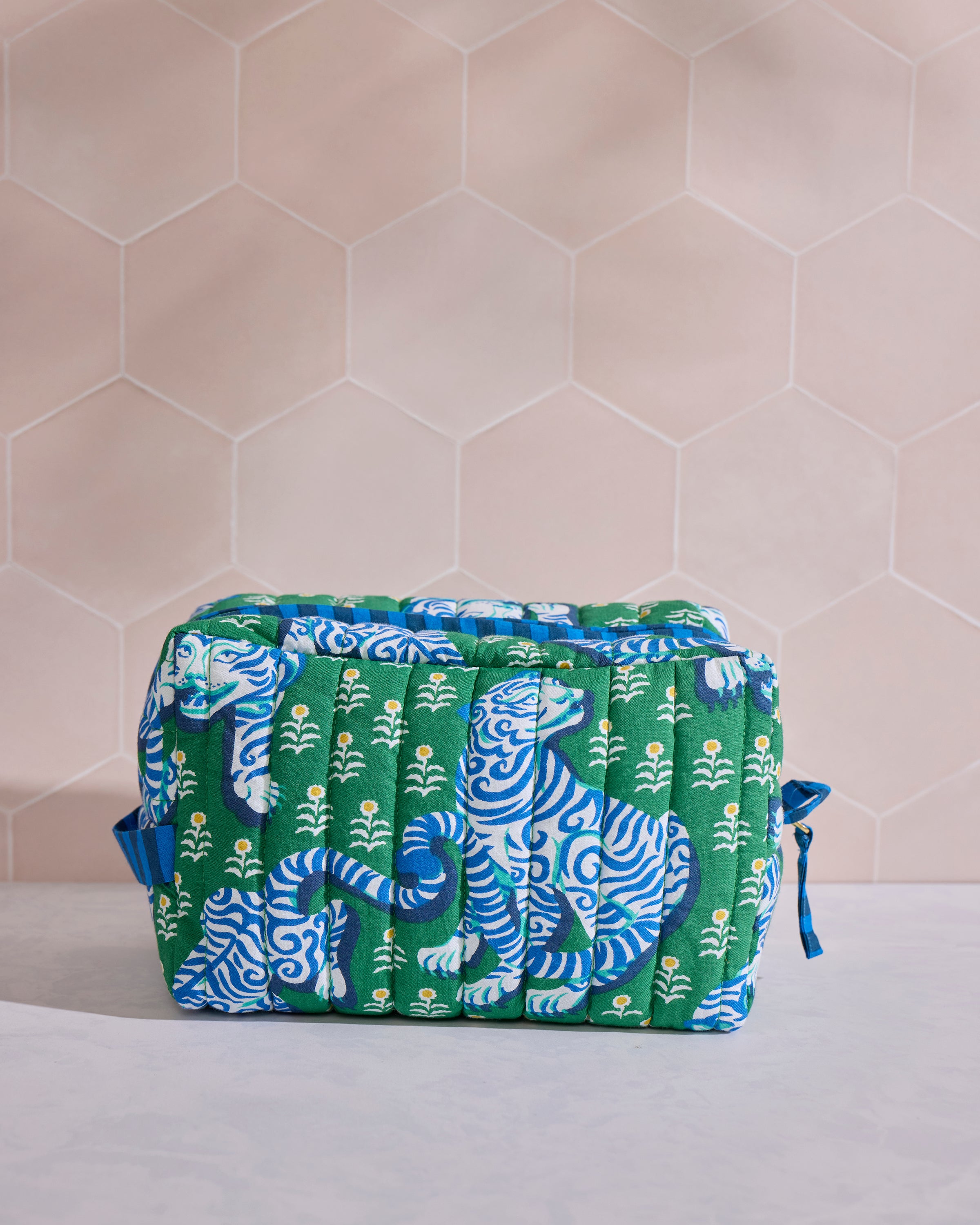 Front view of the green quilted Tiger Queen pouch with blue-and-white tiger motifs and small floral designs.