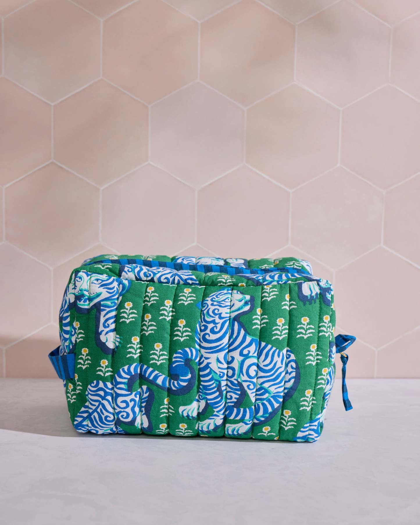 Front view of the green quilted Tiger Queen pouch with blue-and-white tiger motifs and small floral designs.