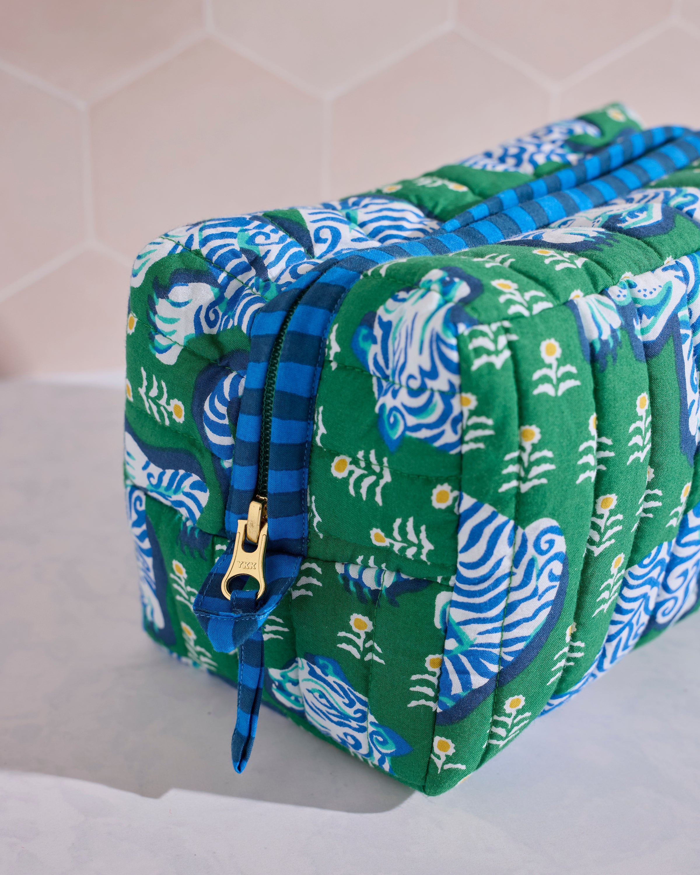 Angled close-up of the quilted Tiger Queen pouch in jade, showing its blue-and-green tiger print and zipper.