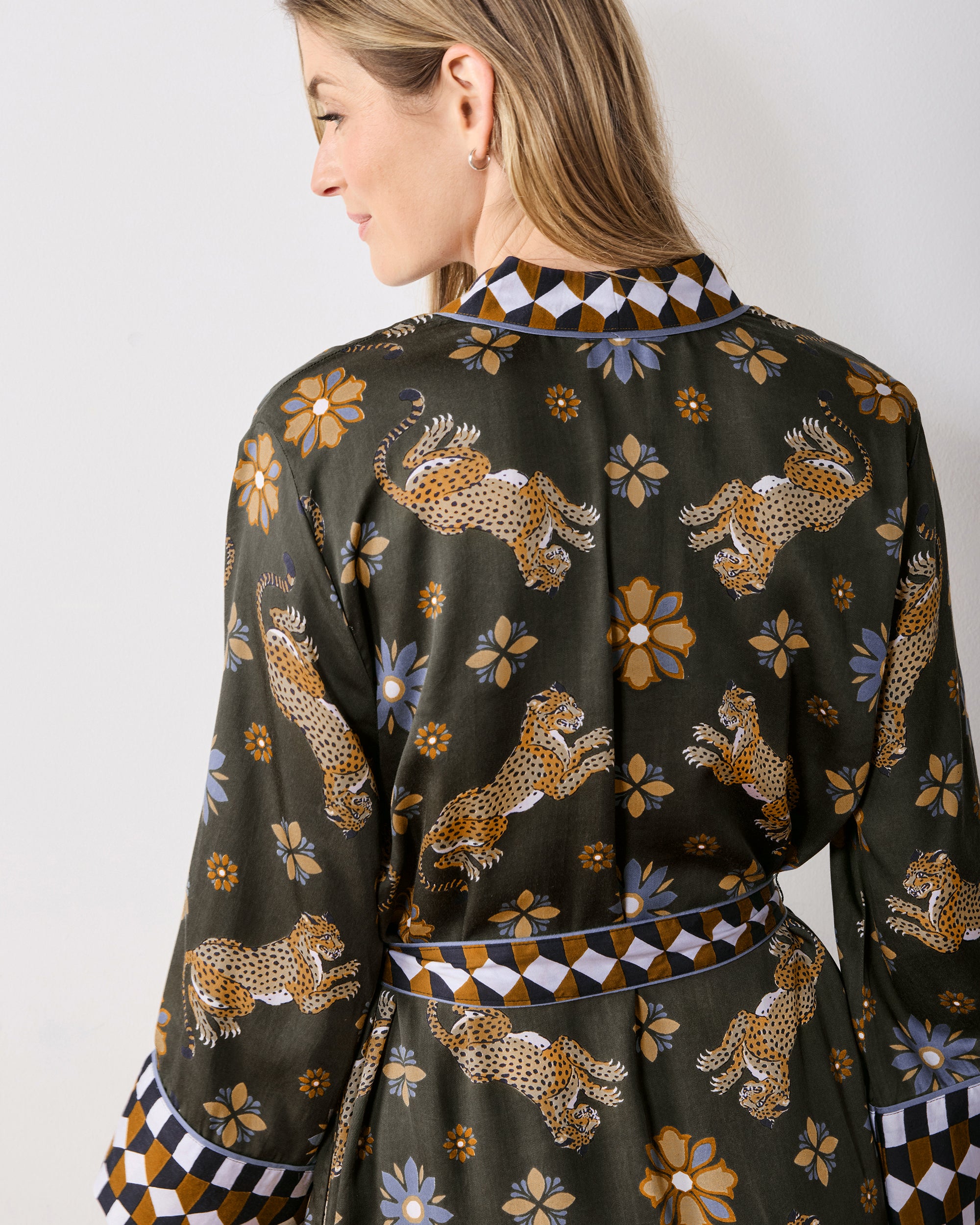 Back view of the olive Bagheera Kaleidoscope Kennedy caftan, showing its leopard-and-flower print and geometric trim at the collar, waist, and cuffs.