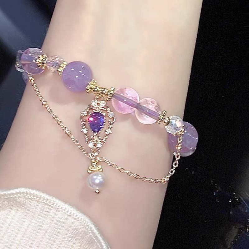 Amethyst bracelet with purple and clear beads, gold accents, held in hand, perfect gift for her.