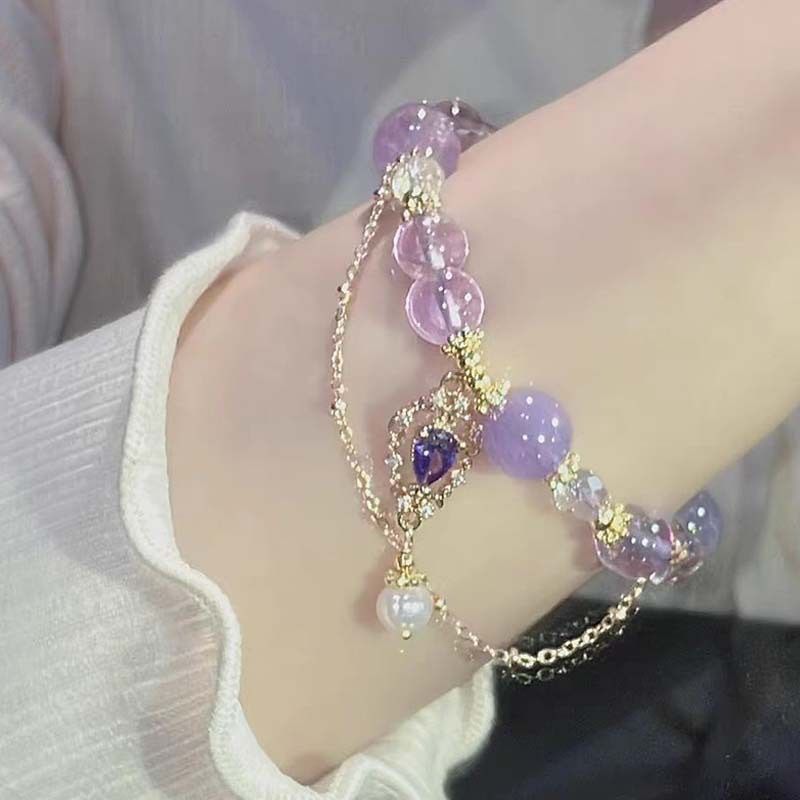 Amethyst bracelet with purple and clear beads, gold accents, held in hand, perfect gift for her.