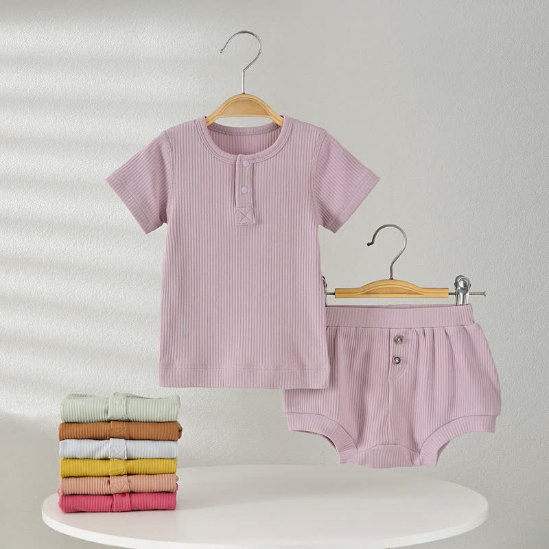Completo pigiama per neonato composto da maglietta e pantaloncini a coste in tinta unita, due pezzi. - image 1