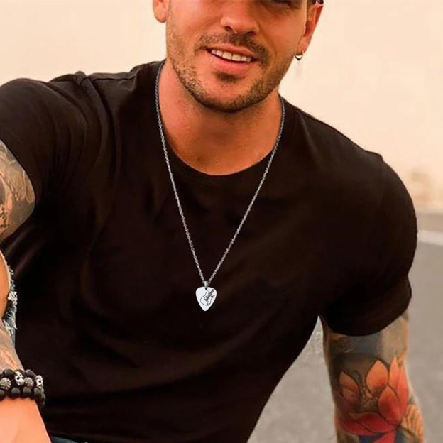 guitar pick necklace on man with sunset beach background
