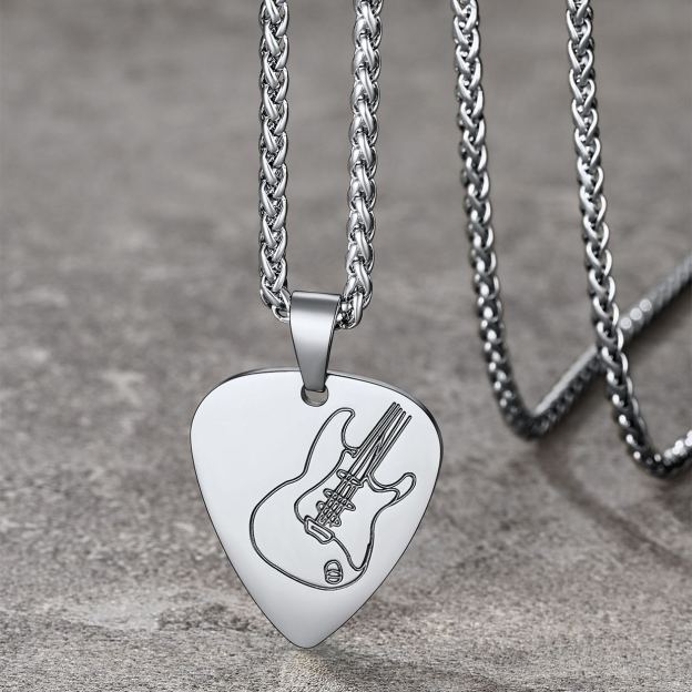stainless steel guitar pick necklace on stone surface 