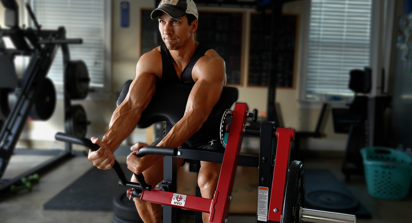 Fitness enthusiast preparing to perform a seated bicep curl on black-red machine
