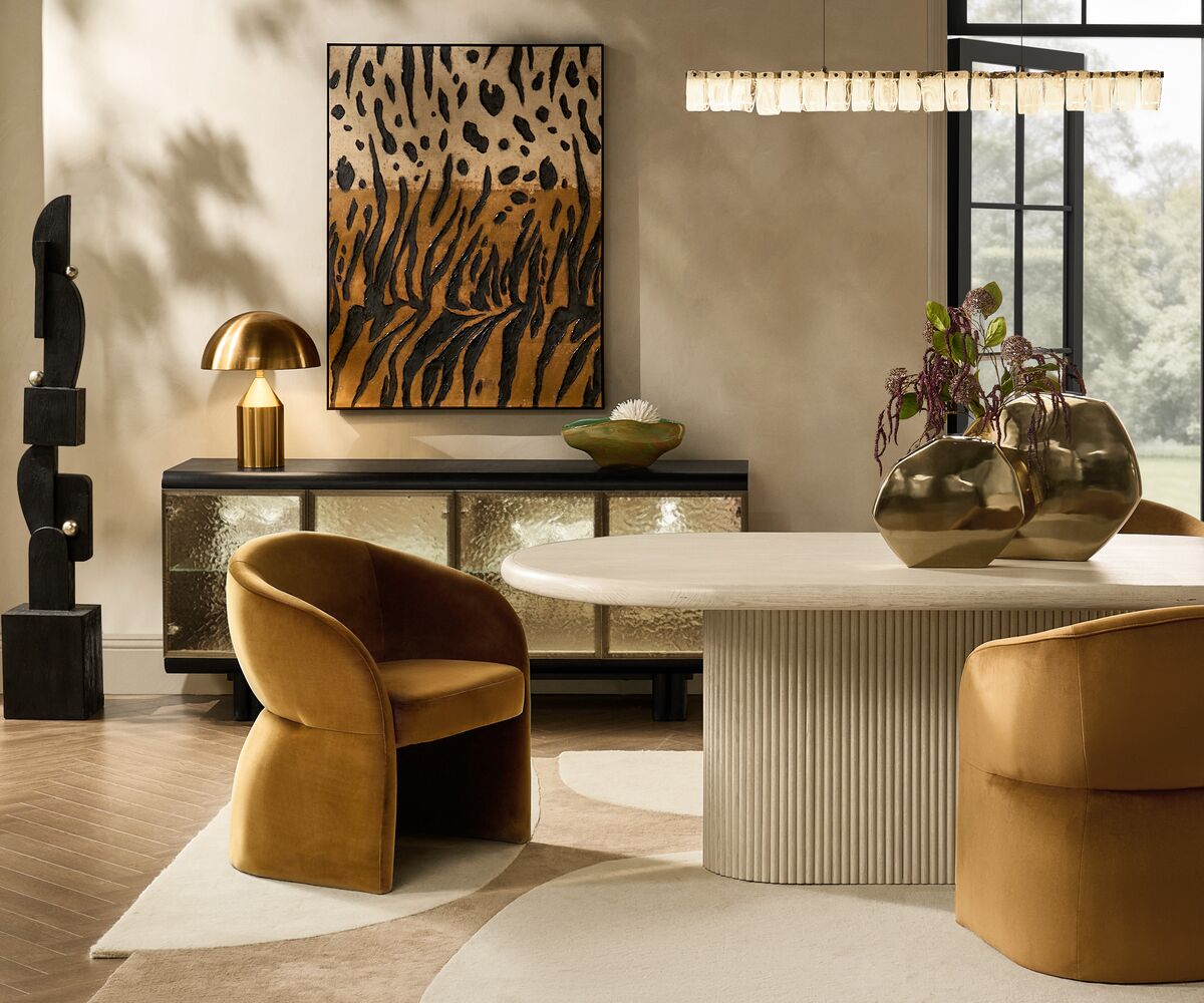 Stria oval dining table with an ivory fluted pedestal base in a luxury dining room setting.