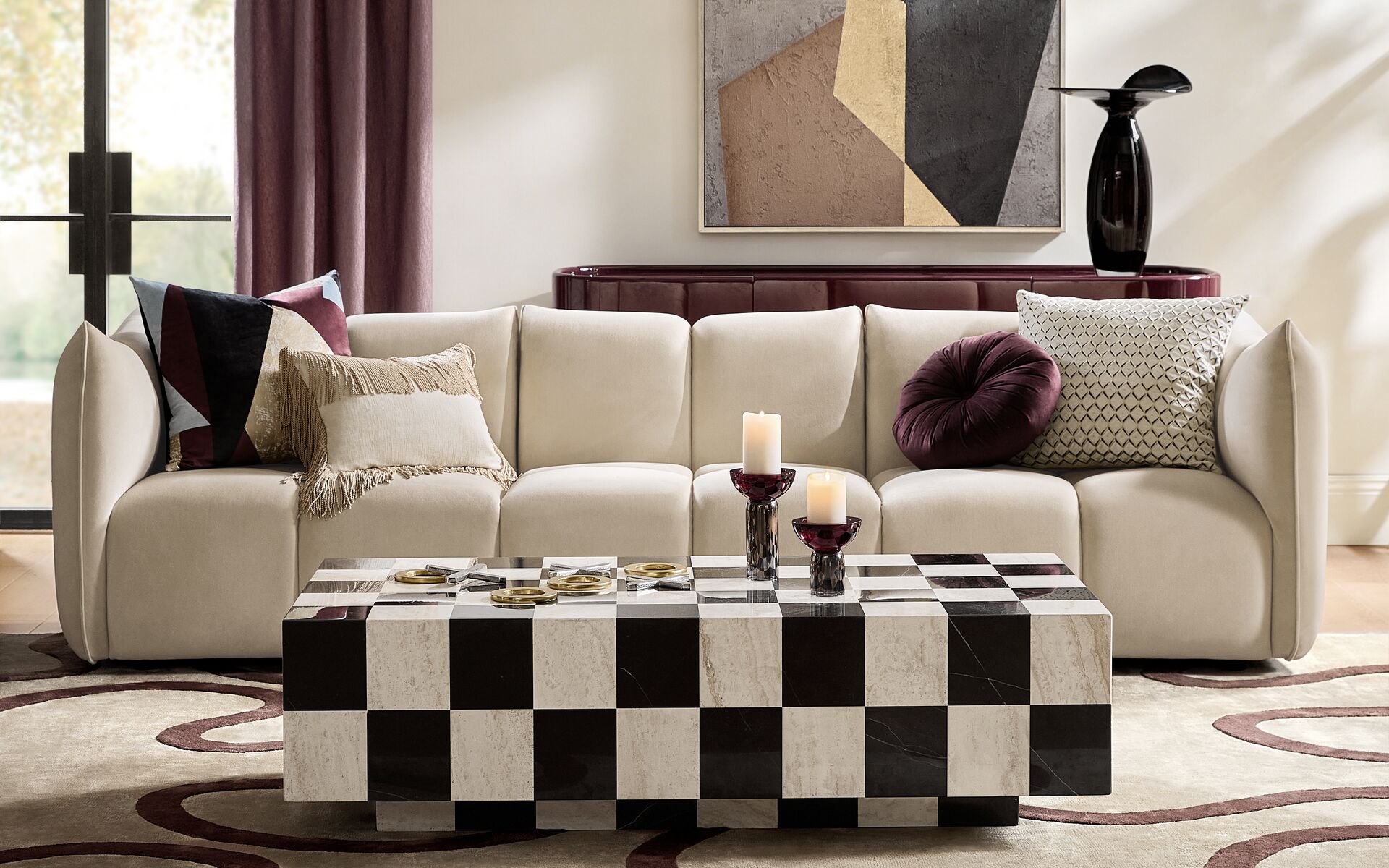 Contemporary modular cream upholstered sofa paired with a black and white checkerboard marble coffee table and geometric wall art.