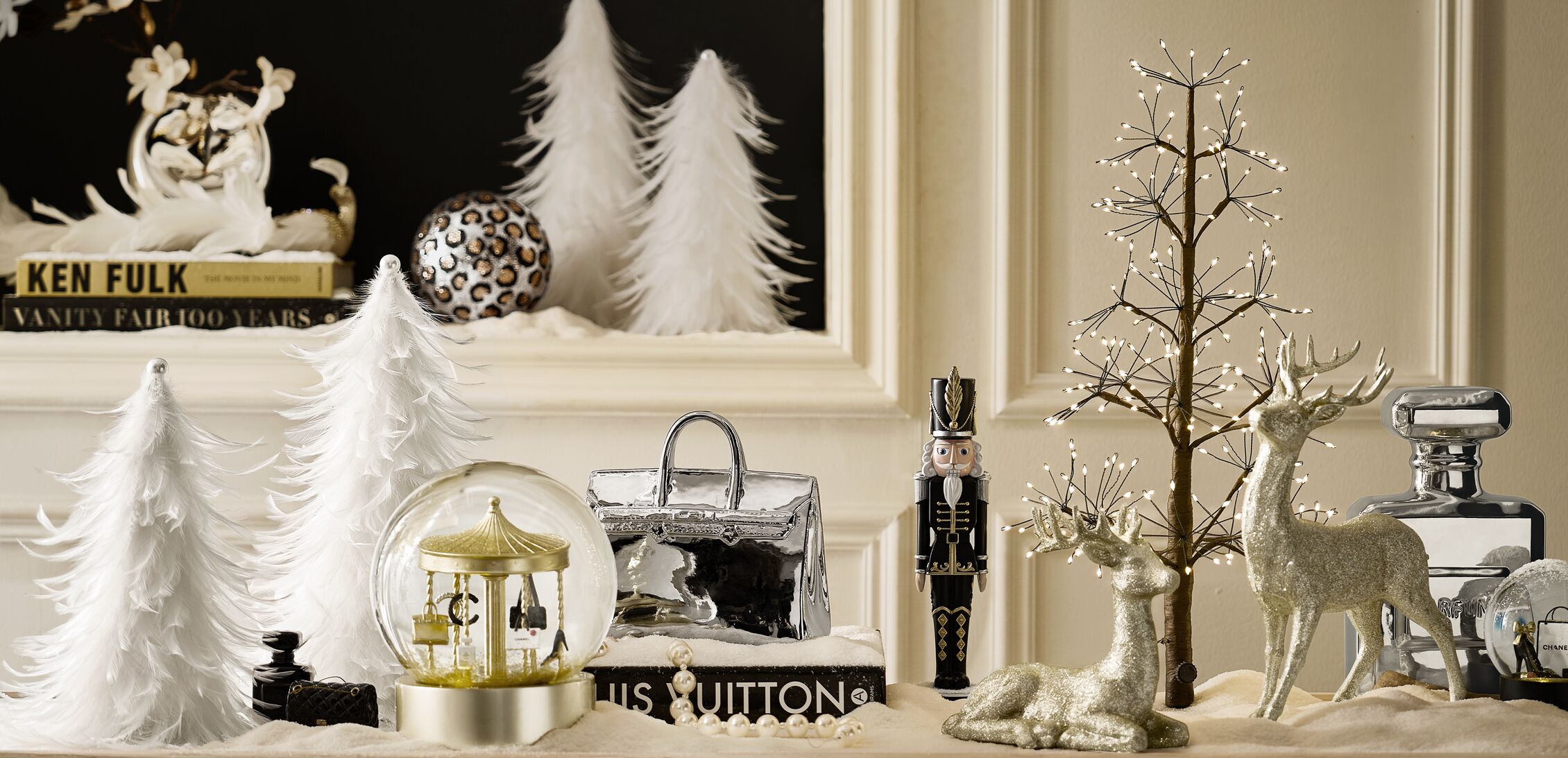A Season of Splendor Christmas gifts banner featuring elegant holiday decor, white feather Christmas trees, sparkling deer figurines, a nutcracker, carousel snow globe, and metallic tabletop accents.