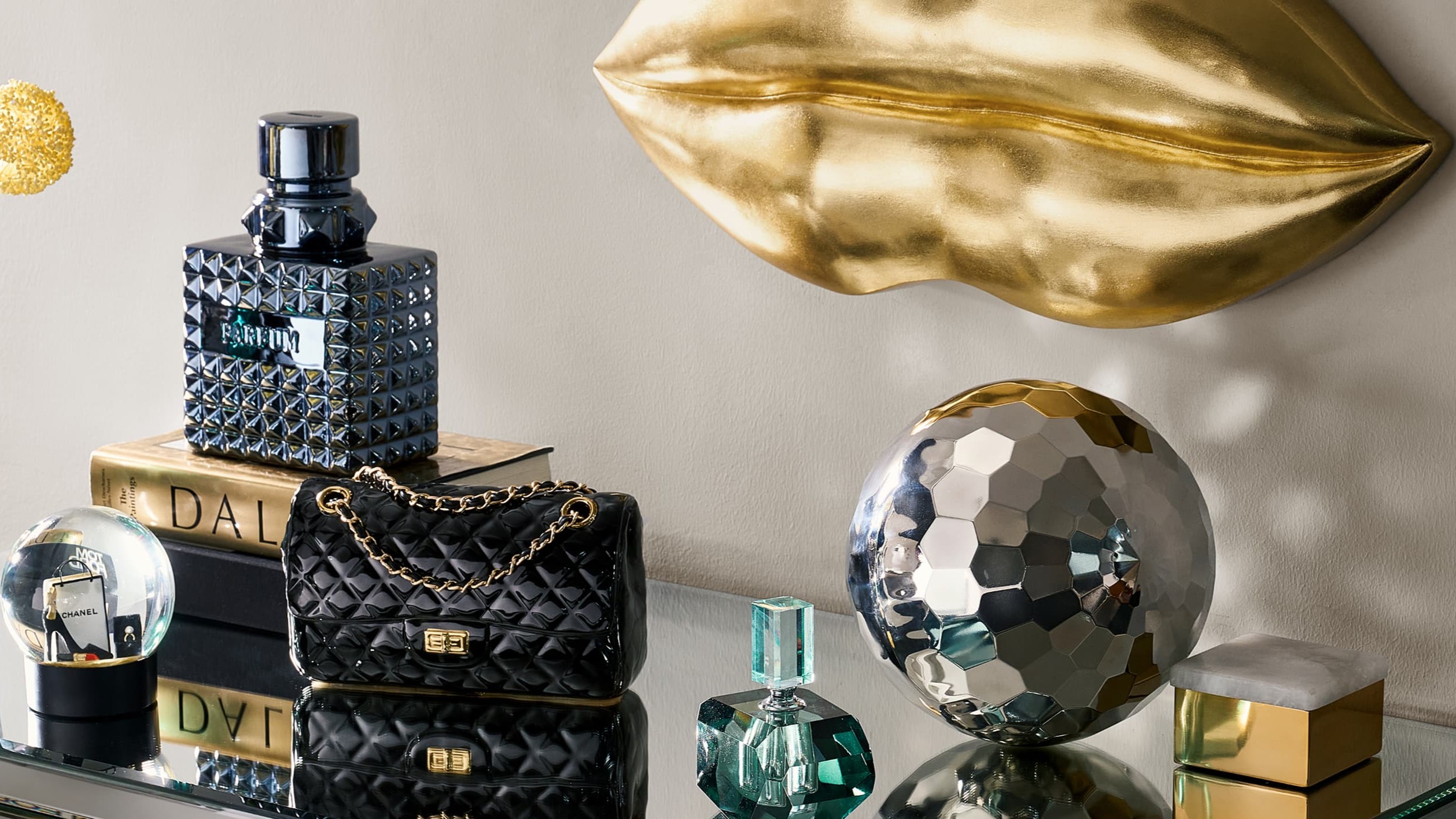 Mirrored surfaces and sculptural accents turn this vignette into a study in shine, contrast, and curated glamour.