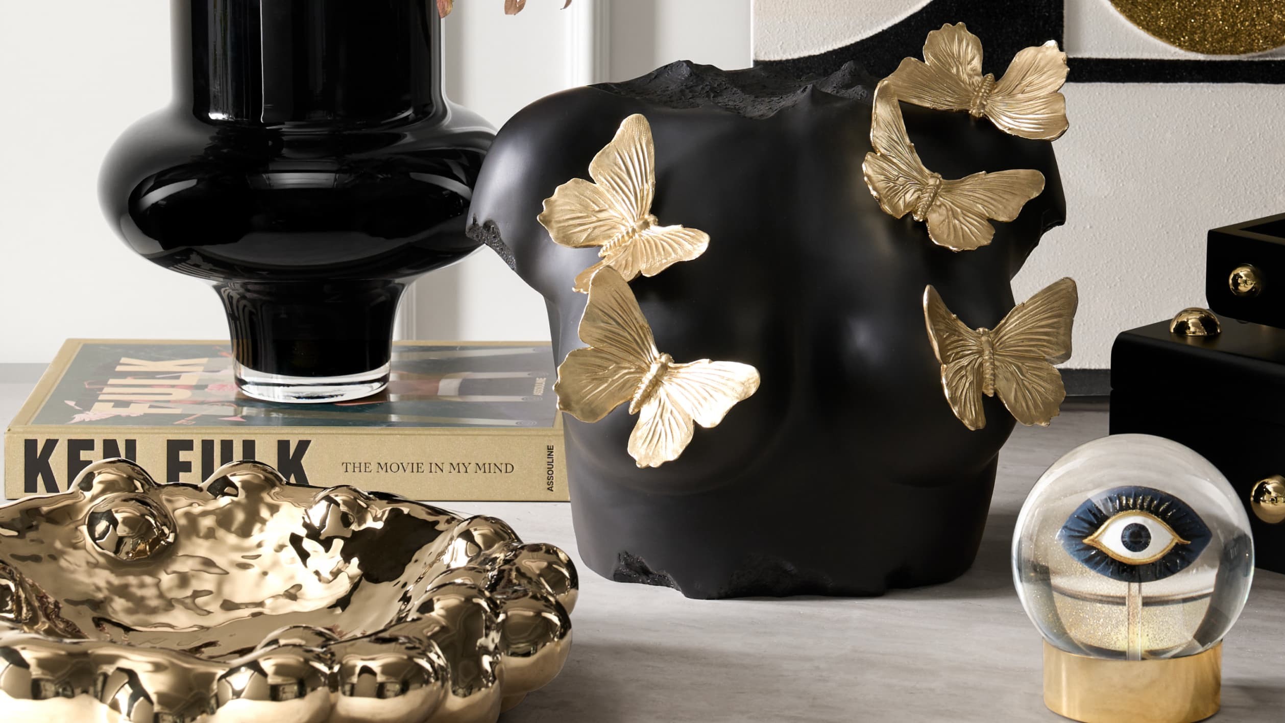 The composition is grounded in deep matte finishes and sharpened by gleaming gold, giving every object a more commanding read.