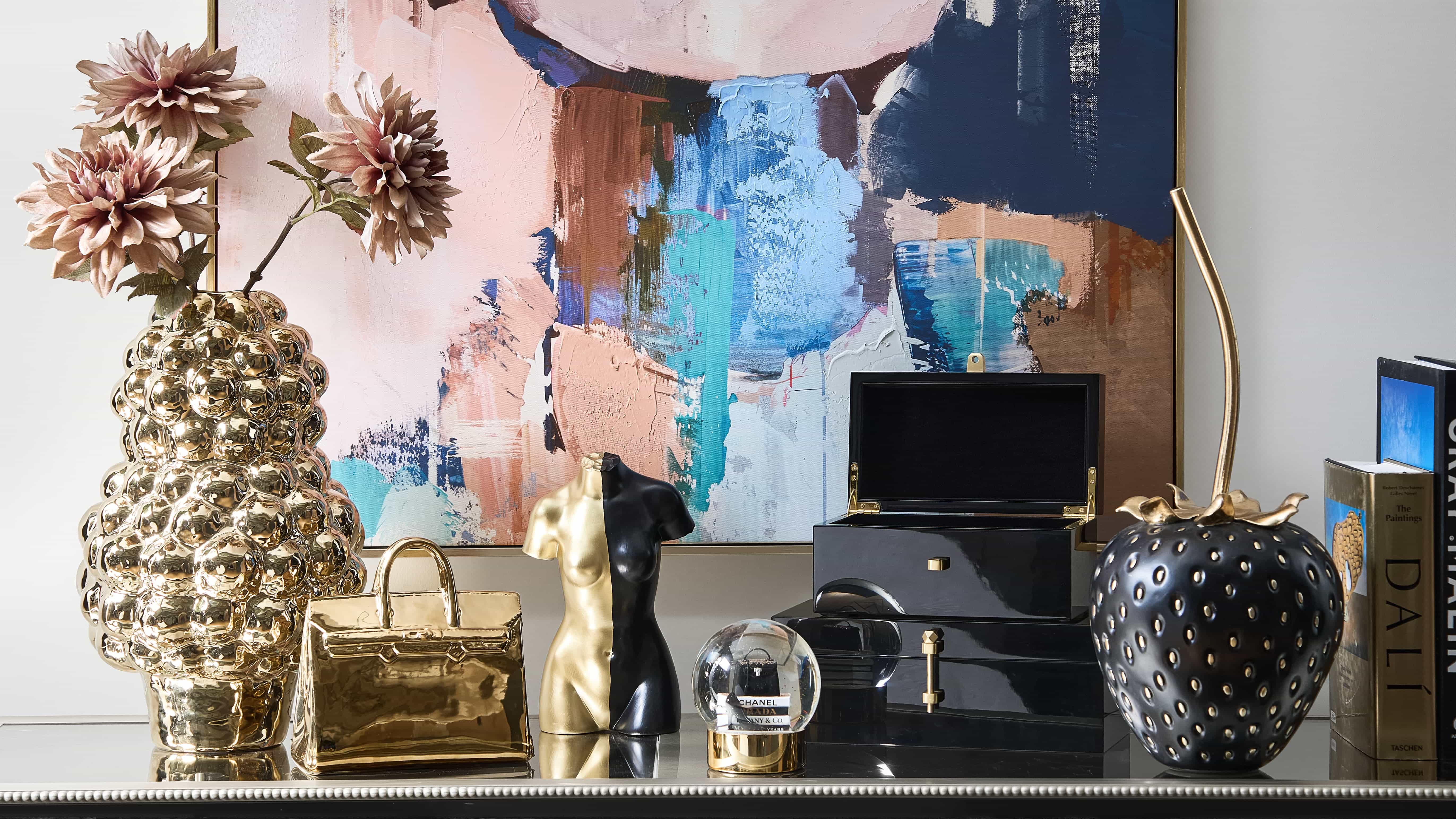 Reflective gold, inky lacquer, and sculptural silhouettes transform the vignette into a statement of decorative confidence.