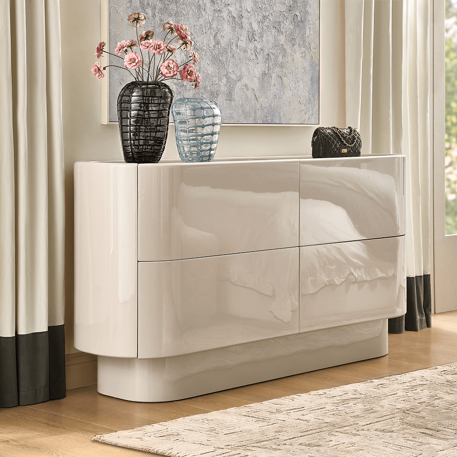 Sleek glossy off-white storage cabinet styled with dark glass vases and pink floral stems.