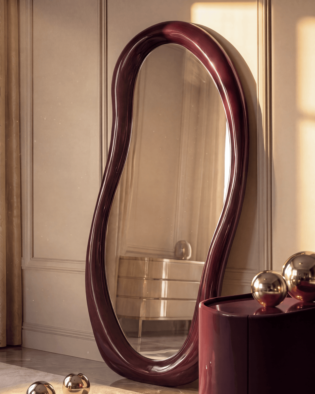 Sway Floor Mirror featuring an undulating sculpted resin frame in high-gloss burgundy lacquer leaning in an elegant sunlit room.