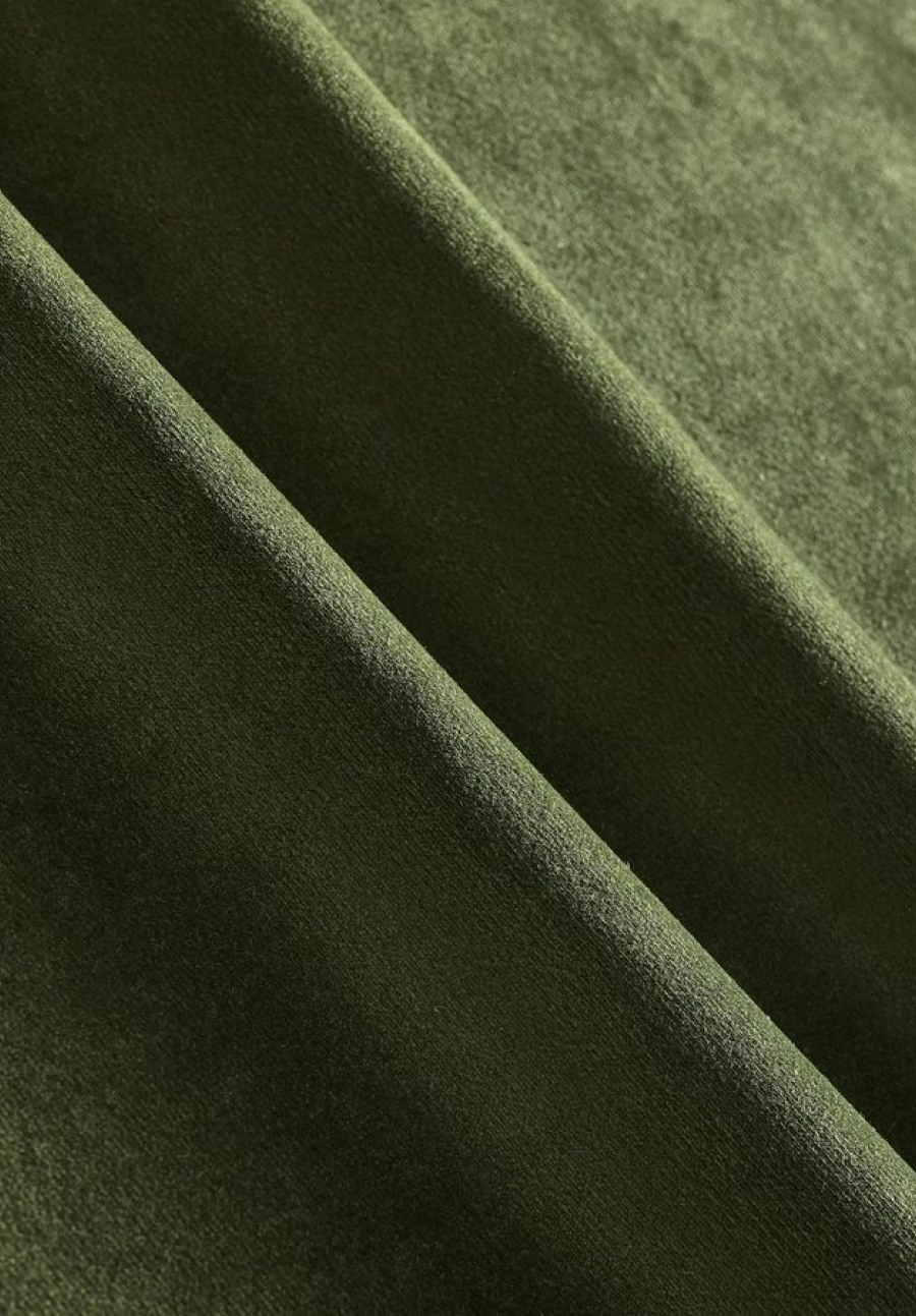 Folded rich olive green velvet upholstery fabric showing soft plush sheen and texture.