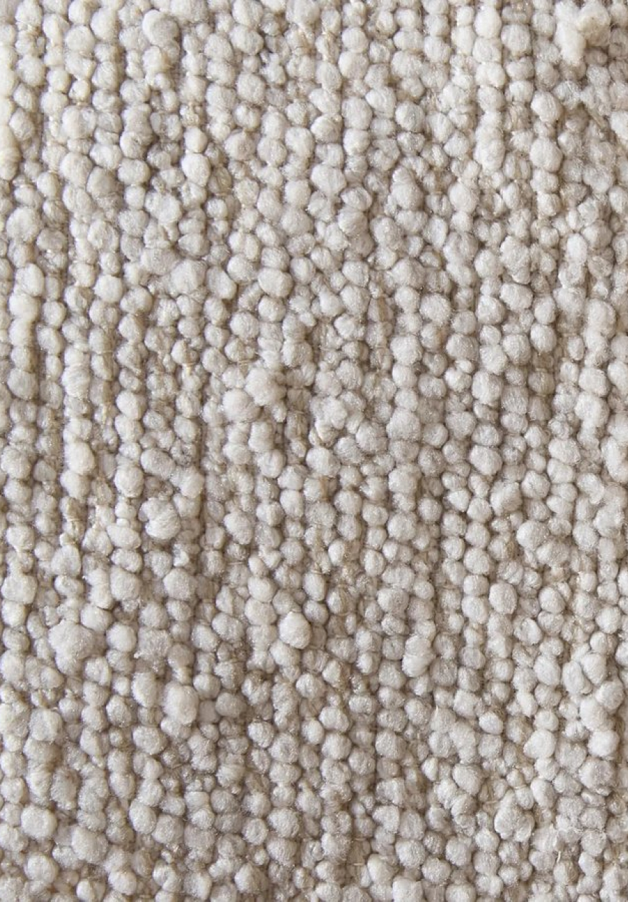 Close-up texture of off-white looped bouclé upholstery fabric.