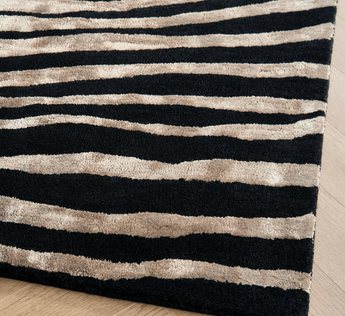 Bold high-contrast graphic rug texture showcasing rich black and metallic gold tiger stripes.