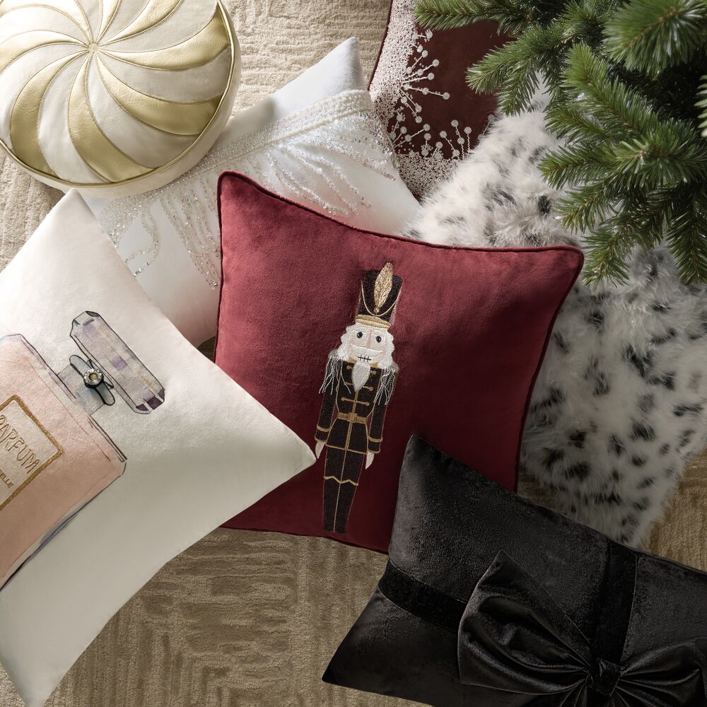 Festive collection of decorative throw pillows featuring an embroidered Nutcracker velvet pillow, holiday accents, and luxury textures.