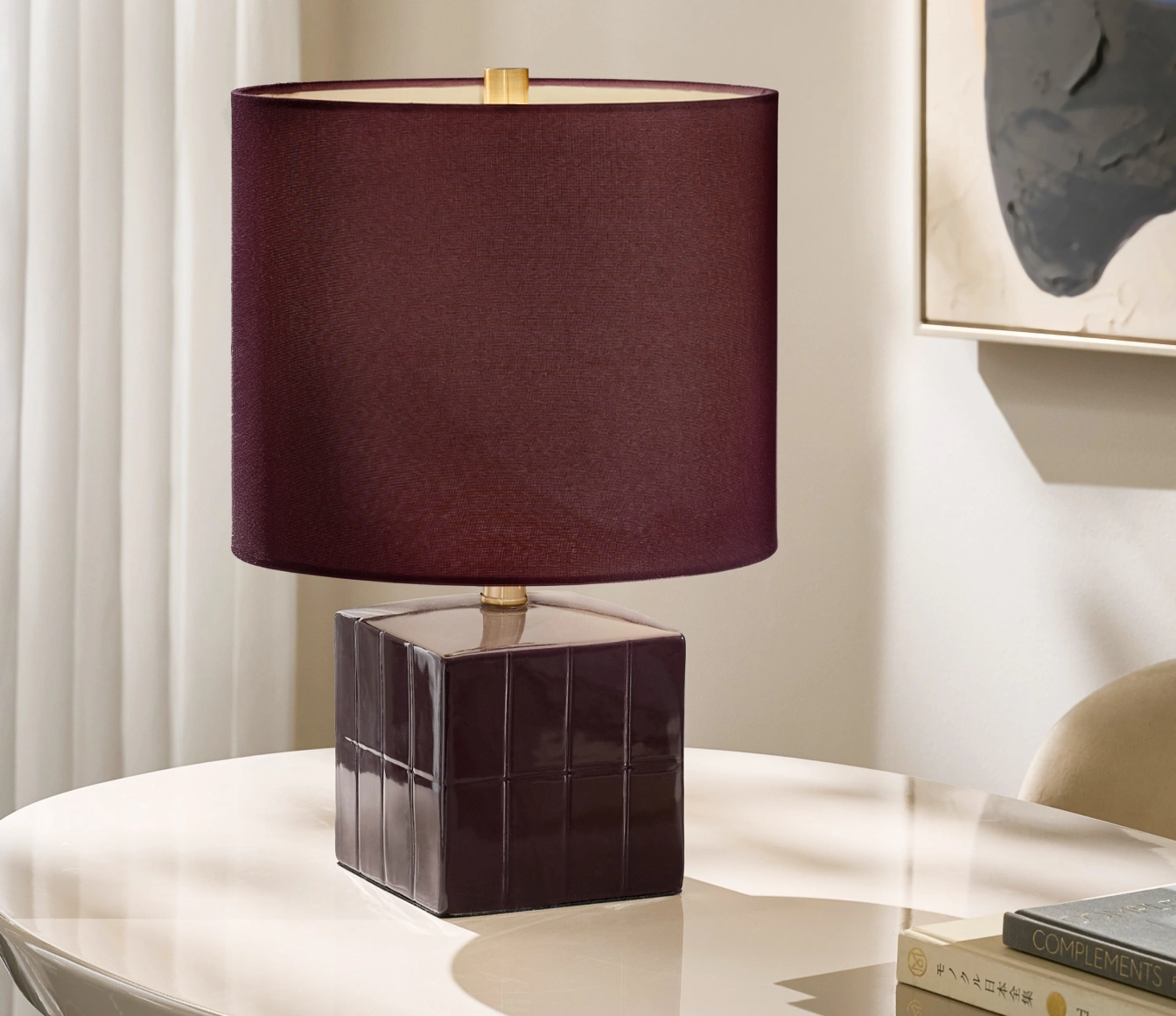 Contemporary table lamp featuring a rich burgundy velvet shade and a high-gloss plum tiled geometric base on a lacquer table.