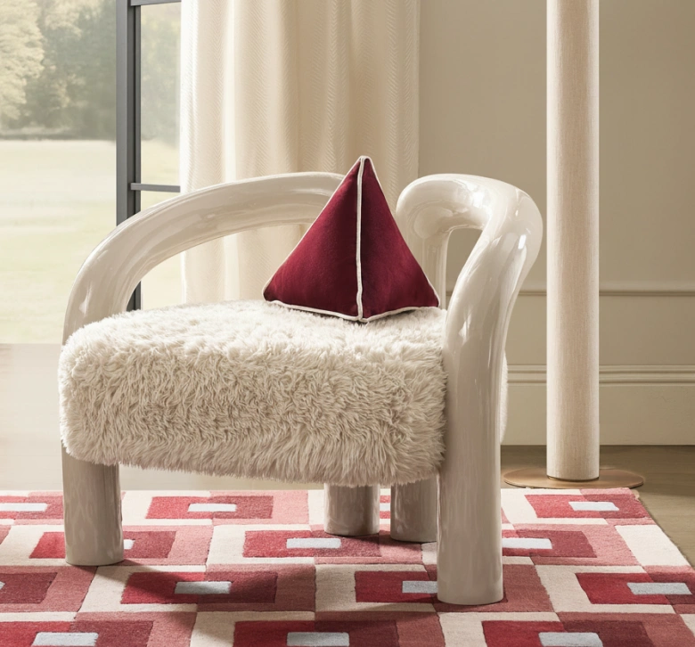 Nia Lacquered Accent Chair featuring a glossy curved backrest and plush textured boucle seat on a patterned rug.
