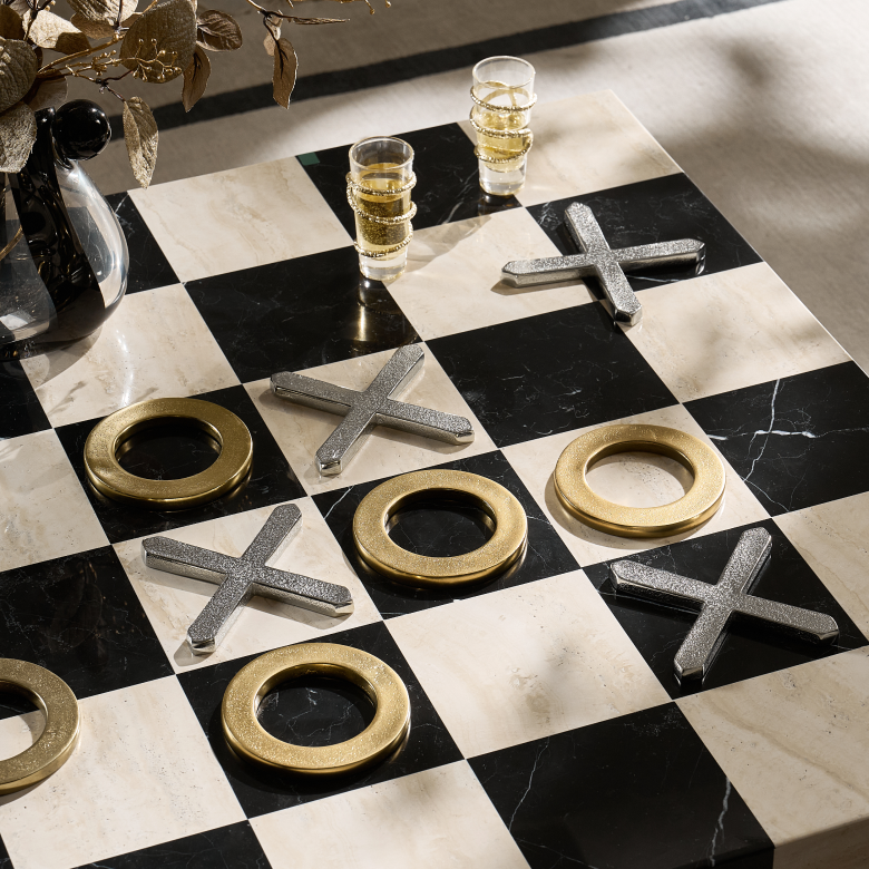 Black and white marble tic-tac-toe game board set with metallic brass and silver playing pieces.