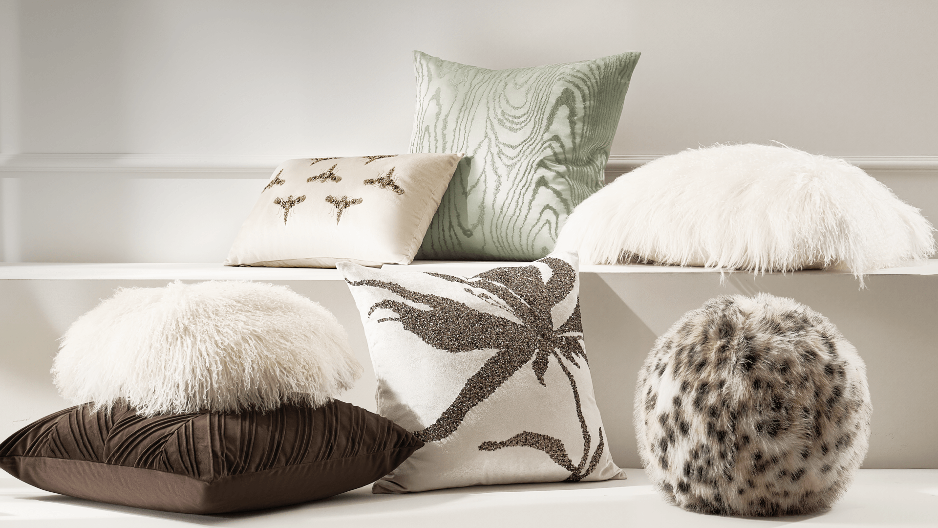 Assortment of textured decorative throw pillows featuring faux fur, embroidered leaf motifs, woodgrain patterns, and a leopard print sphere cushion.